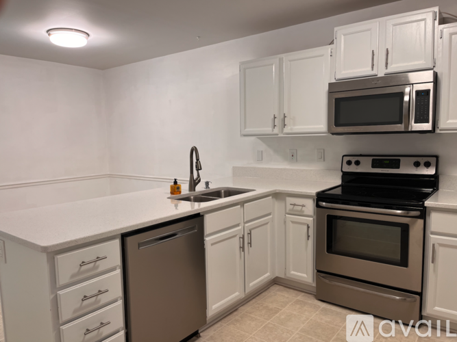 A kitchen with white cabinets and a black stove top oven.