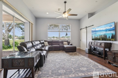 A living room with a large leather sofa and a television.