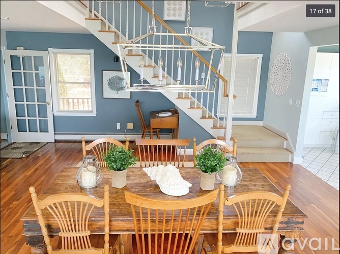 A dining room with a wooden table and chairs.