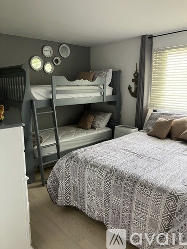 A bedroom with a bed, bunk beds, and a dresser.