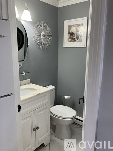 A bathroom with a toilet, sink, and mirror.