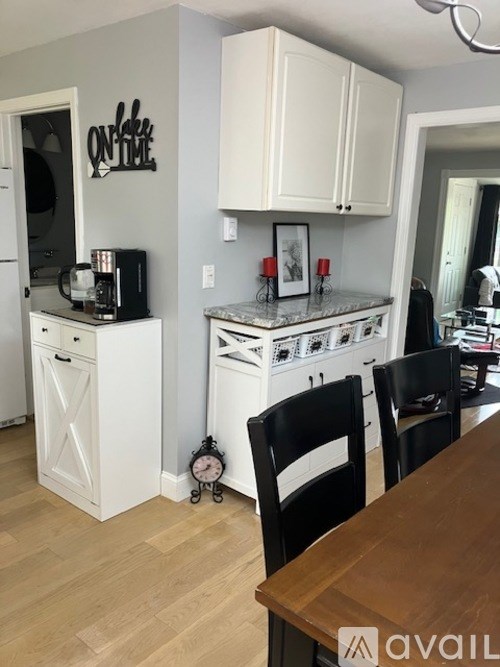 A kitchen with white cabinets and a wooden table.
