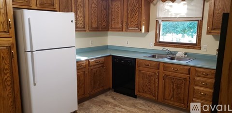 A kitchen with wooden cabinets and a white fridge.