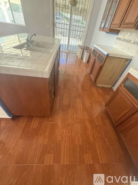 A kitchen with wooden floors and white countertops.