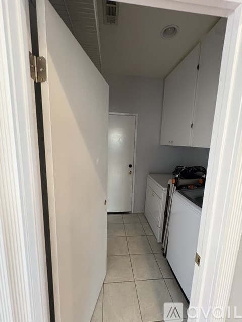 A kitchen with white cabinets and appliances.