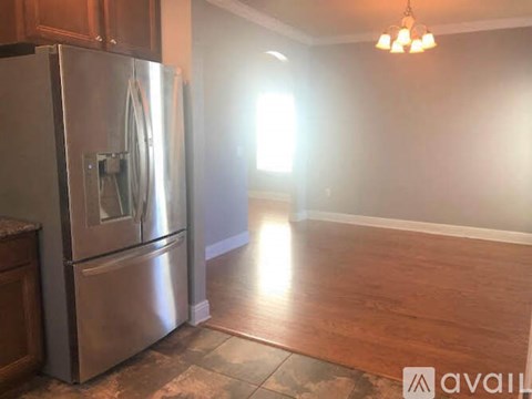 A kitchen with a stainless steel refrigerator and wooden cabinets.