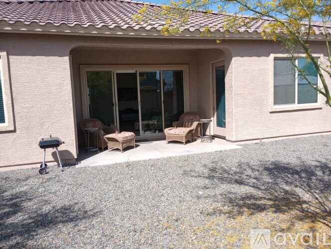 A house with a patio and a BBQ grill.