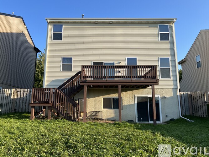 A two-story house with a deck and stairs leading to the second floor.