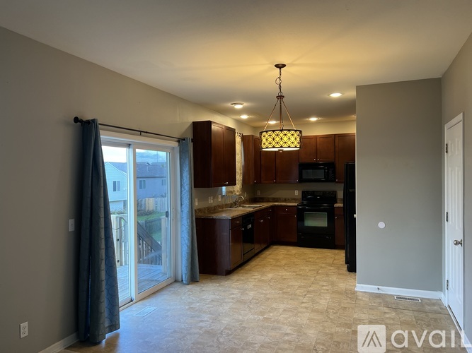 A kitchen with brown cabinets and a black stove top oven.