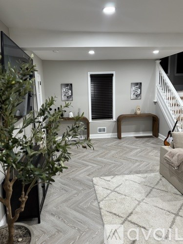 A living room with a grey carpet and a white couch.
