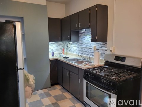A kitchen with black cabinets and a checkered floor.