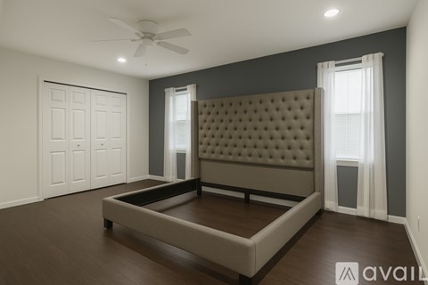 A bedroom with a large bed and a ceiling fan.