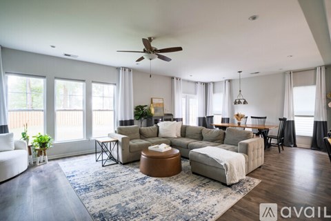A spacious living room with a large sectional sofa and a rug in the center.
