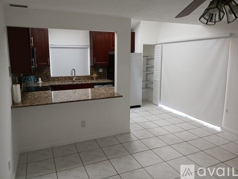 A kitchen with brown cabinets and a white refrigerator.