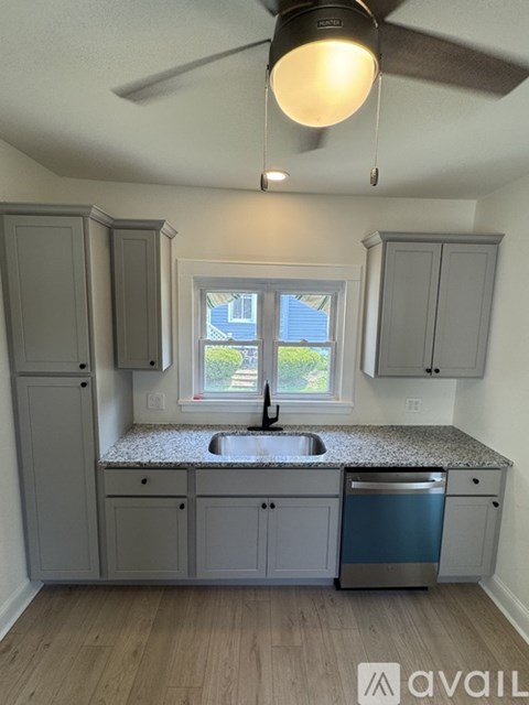 A kitchen with a window and a ceiling fan.