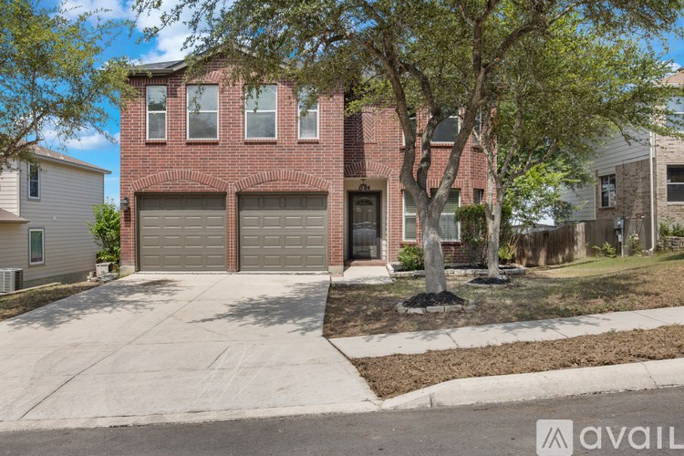 A red brick house with a tree in front.