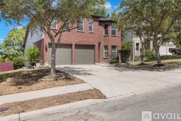 A red brick house with a tree in front.