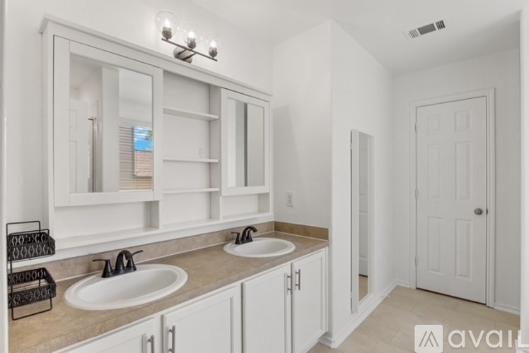 A bathroom with two sinks and a large mirror above them.