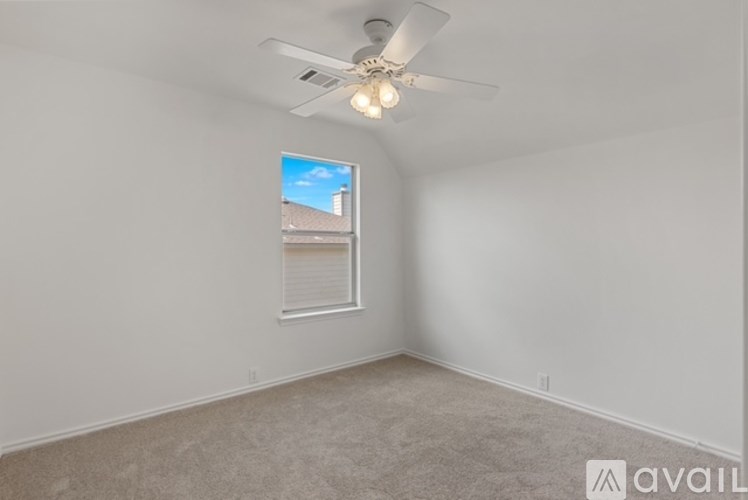A room with a ceiling fan and a window showing a view of a building outside.
