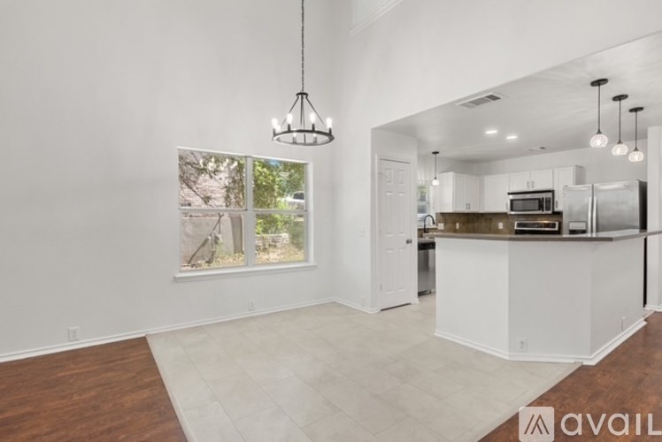 A modern kitchen with white cabinets and a wooden island.