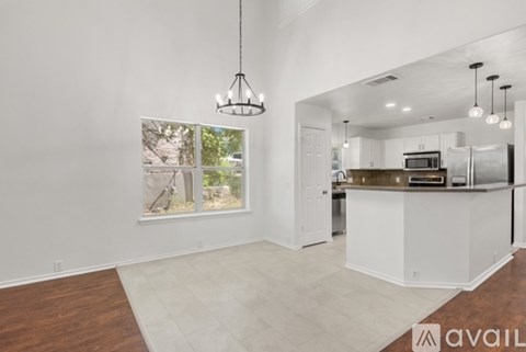 A modern kitchen with white cabinets and a wooden island.