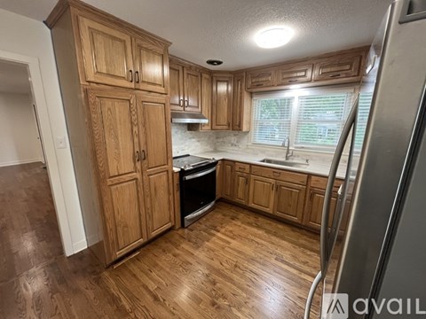 A kitchen with wooden cabinets and a refrigerator.