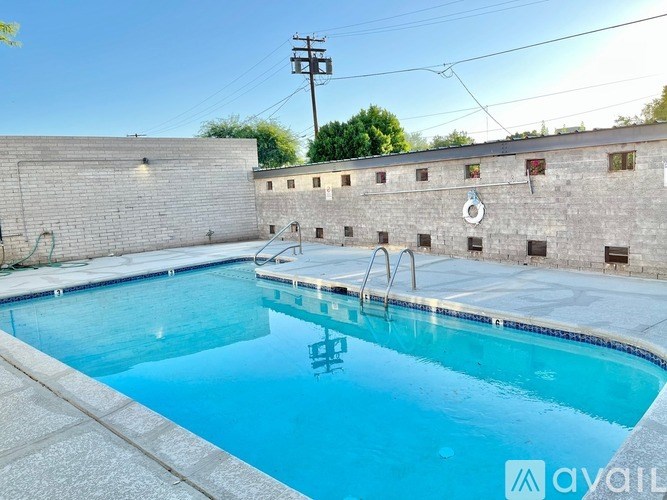 A pool in a yard with a wall around it.