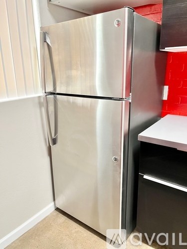 A stainless steel refrigerator with its door open in a kitchen.