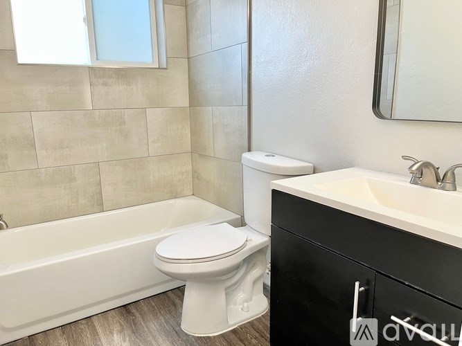 A white toilet sits next to a bathtub in a bathroom.