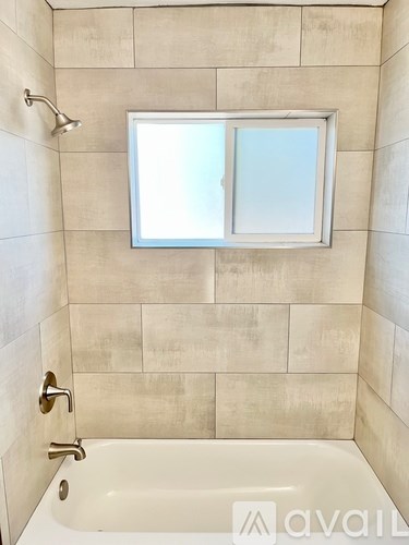 A bathroom with a tub and a window.