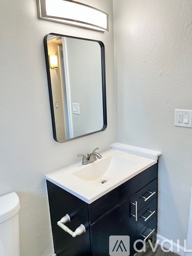 A bathroom with a sink, toilet and mirror.