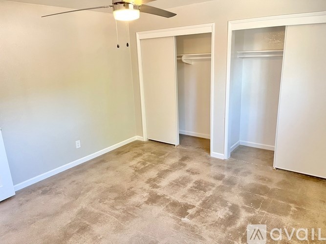 A room with a ceiling fan and carpeted floor.