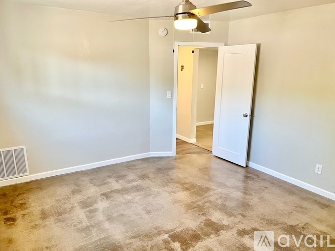 A room with a ceiling fan and carpeted floor.