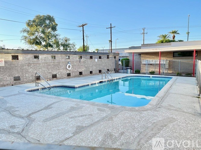A pool with a stone wall and a diving board.