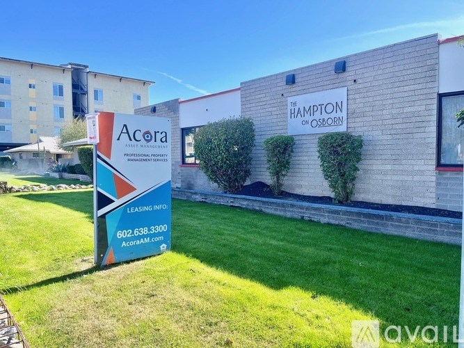 A sign for Acora Management Services stands in front of a building.