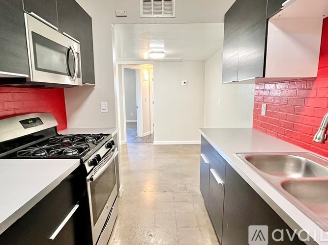A kitchen with a stove, microwave, and sink.
