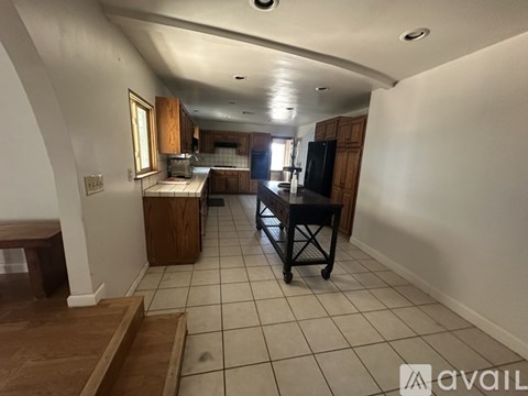 A kitchen area with a table and chairs in the middle of the room.