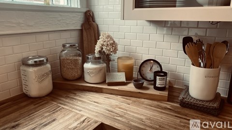 A kitchen counter with utensils and jars on it.
