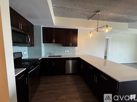 A kitchen with dark brown cabinets and a stainless steel dishwasher.