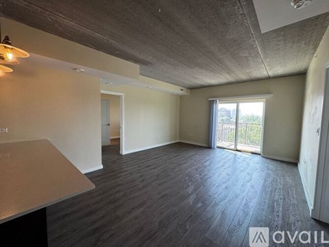 A spacious room with a concrete ceiling and a large window.