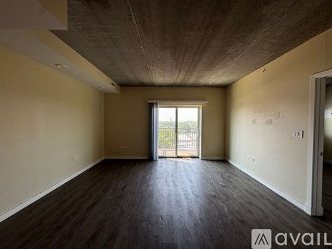 A spacious room with wooden floors and a slanted ceiling.