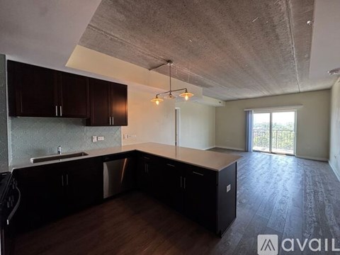 A kitchen with dark wood cabinets and a concrete ceiling.