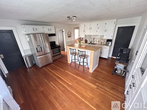 A kitchen with wooden floors and stainless steel appliances.