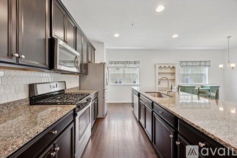 A kitchen with dark wood cabinets and granite countertops.