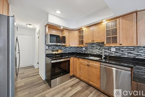A kitchen with wooden cabinets and a black countertop.