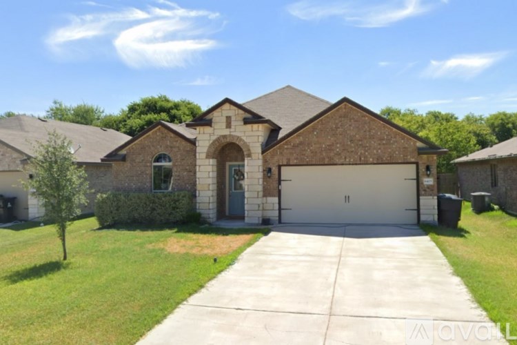 A brick house with a driveway in front.