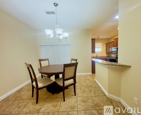 A dining room with a table and chairs.