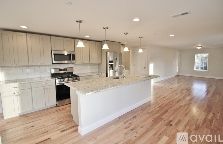 A kitchen with wooden floors and a central island.