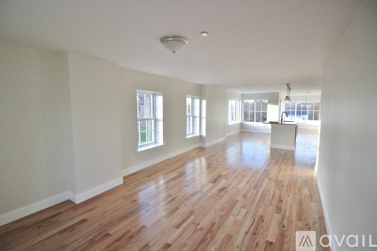 A room with wooden floors and white walls is available for rent.