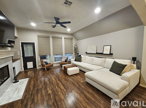 A living room with a white couch and a fireplace.